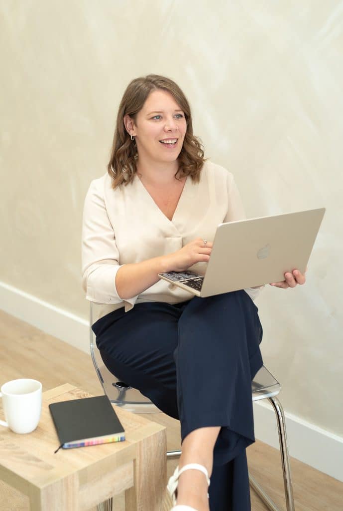 helen saniforth, sitting holding laptop, public speaking trainer